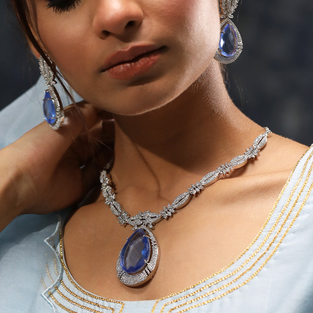 A woman wearing Imperial Elegance American Diamond Necklace (Blue) with Earrings.