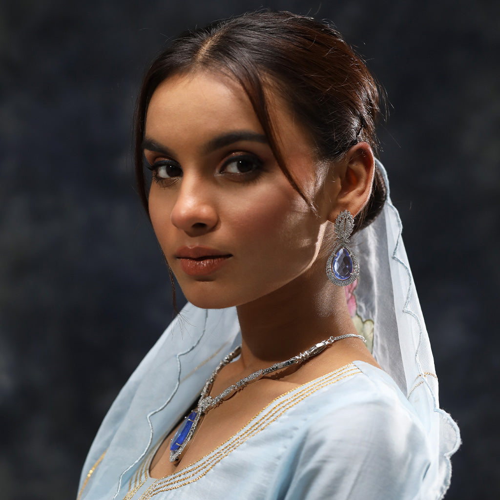 A woman wearing Imperial Elegance American Diamond Necklace (Blue) with Earrings.